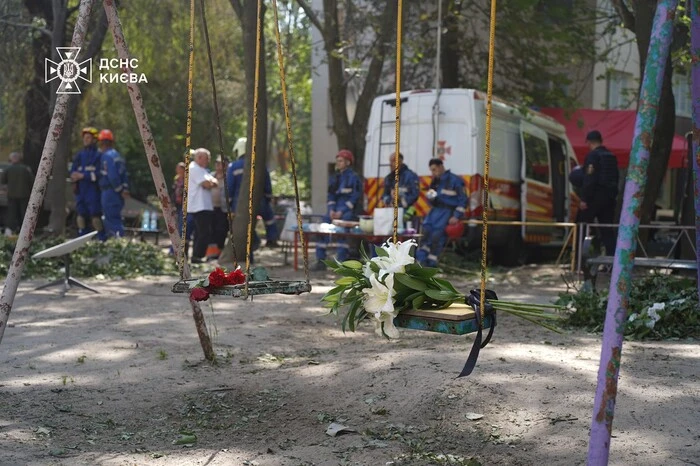 Кияни несуть квіти до знищеного росіянами будинку, де тривають пошукові роботи (фото)